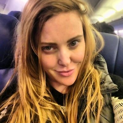 Kate Quigley is taking a selfie in what looks like in a plane.